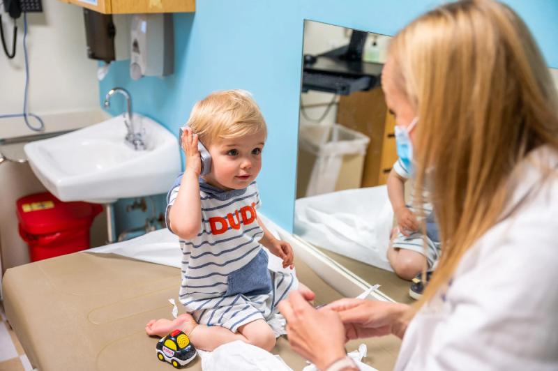 a blond child on an exam table with a doctor